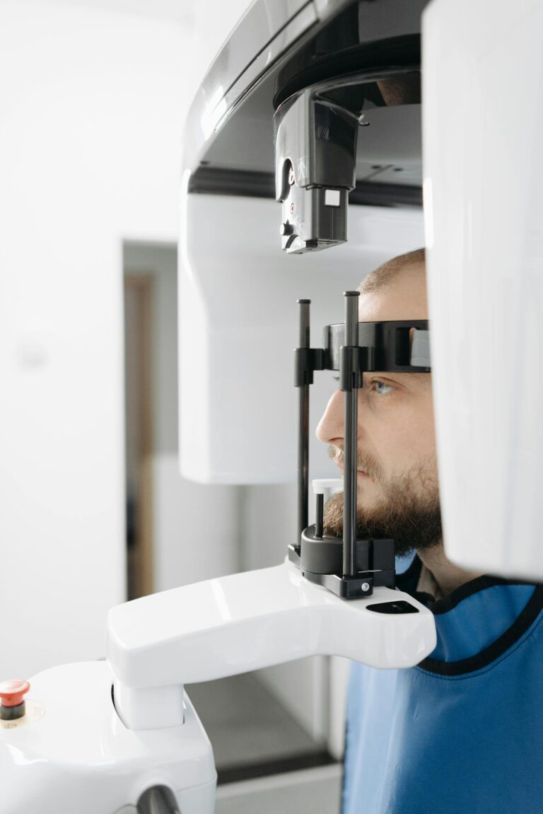 A male patient undergoing a panoramic dental X-ray scan in a modern clinic.